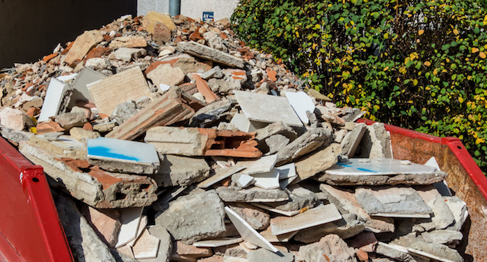 demolition construction site debris container full of concrete pieces, plaster pieces, and building demolition debris