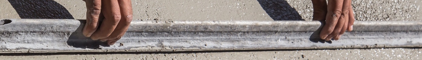 two hands smoothing, or screeding, freshly poured sidewalk concrete